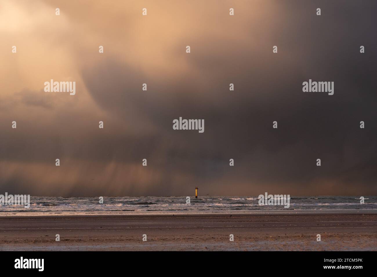 Gelber Messstab in der Nordsee, in der Nähe des Strandes, im Kontrast zu dunklen Wolken, aus denen Regen fällt Stockfoto