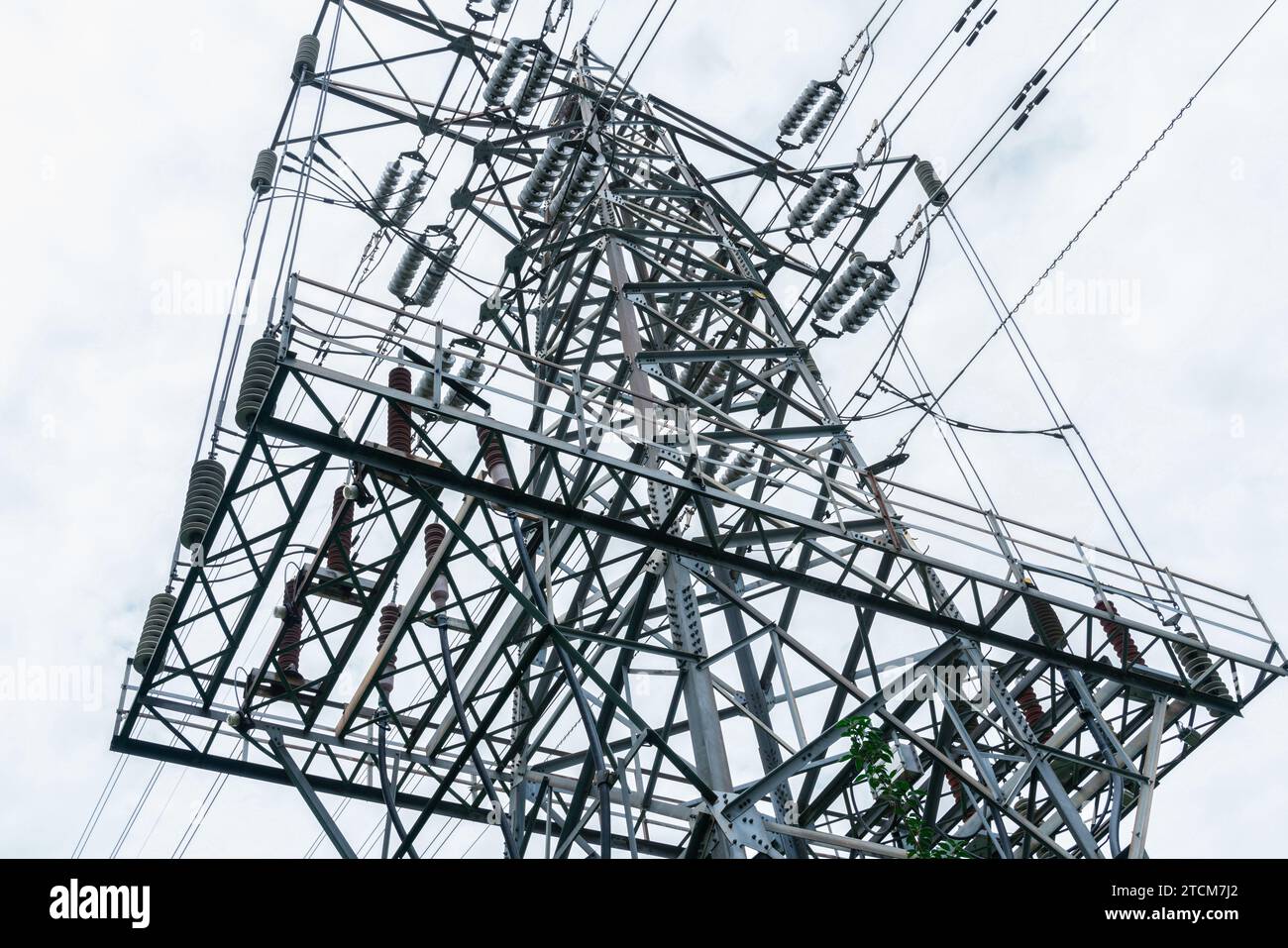 Ein Bild eines elektrischen Posts mit einer hohen Metallstruktur, die von verschiedenen elektrischen Drähten umgeben ist Stockfoto