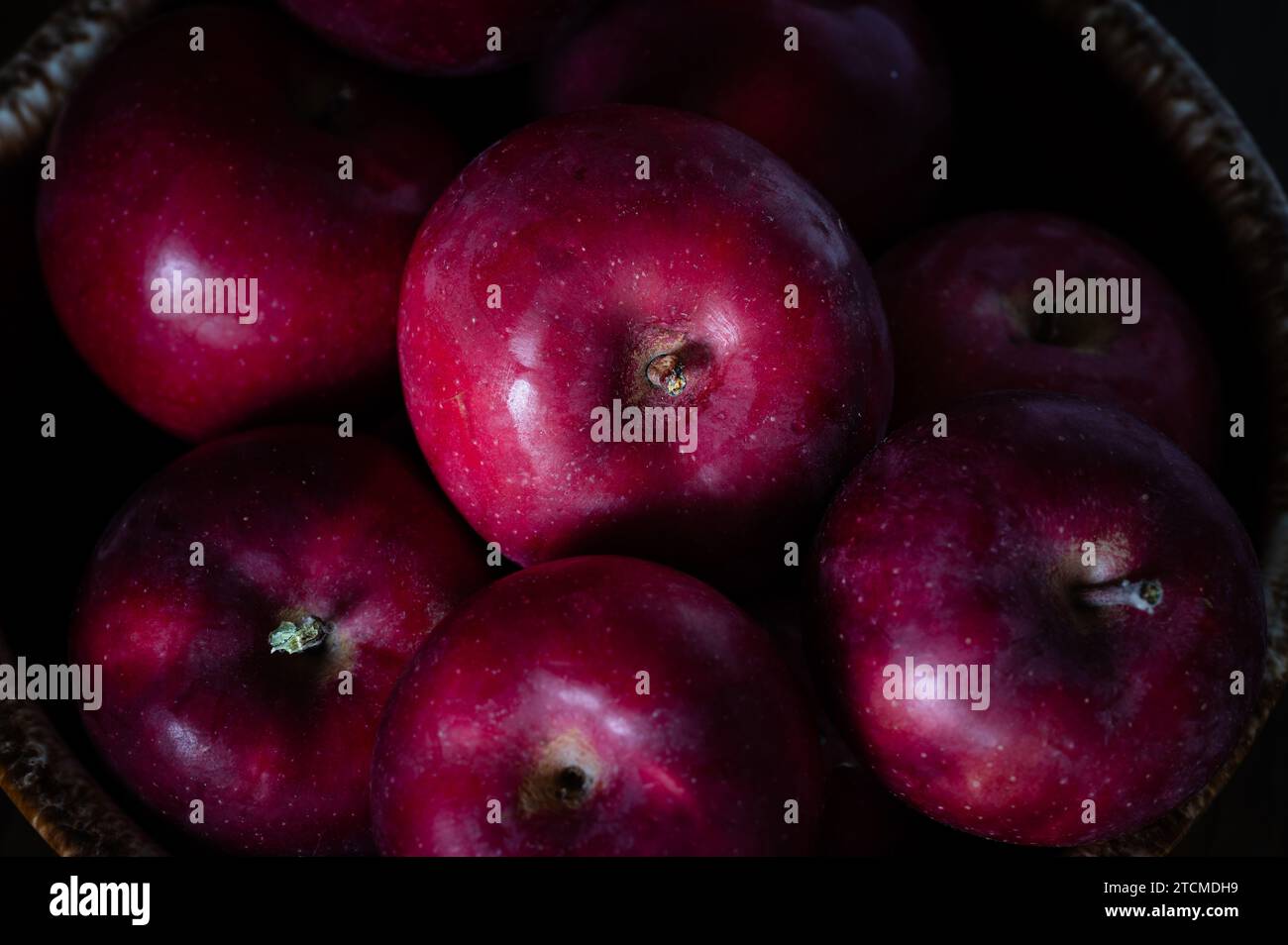 Rote Äpfel, die aus einer braunen Schale auslaufen Stockfoto