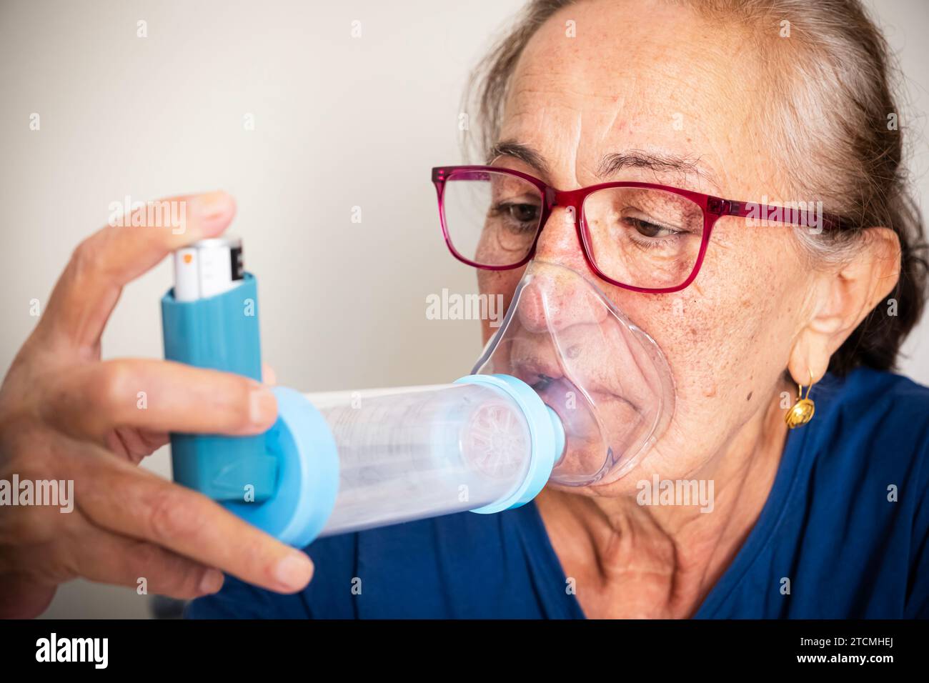 Kranke Seniorin, die Inhalation mit Vernebler macht. Asthmatische Frau mit Inhalator. Stockfoto