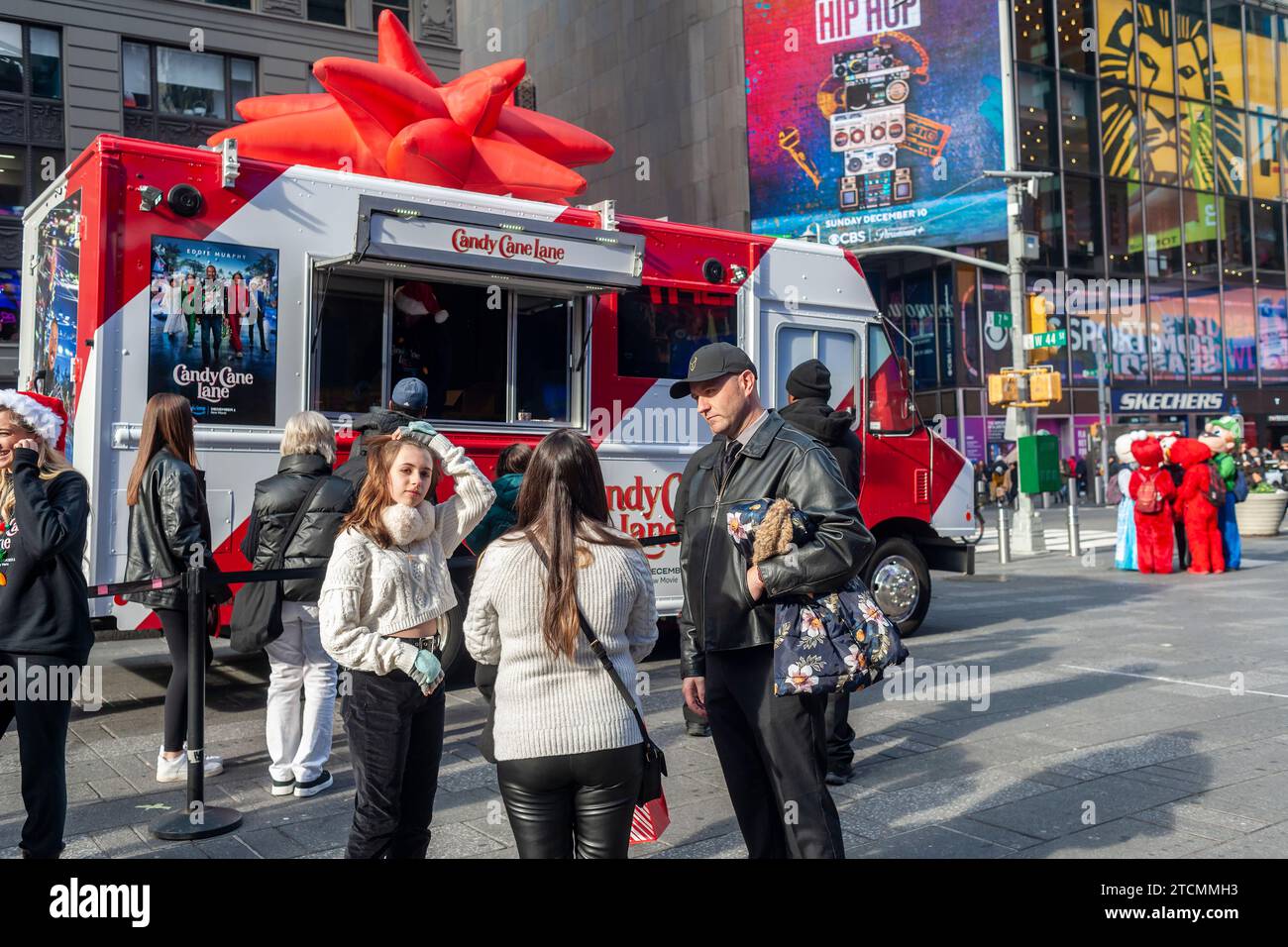 Bei einer Markenaktivierung des „Candy Cane Lane“-Films von Amazon Prime Videos mit Eddie Murphy am Samstag, den 2. Dezember 2023, im Times Square in New York warten die Leute online auf kostenlose heiße Schokolade. (© Richard B. Levine) Stockfoto