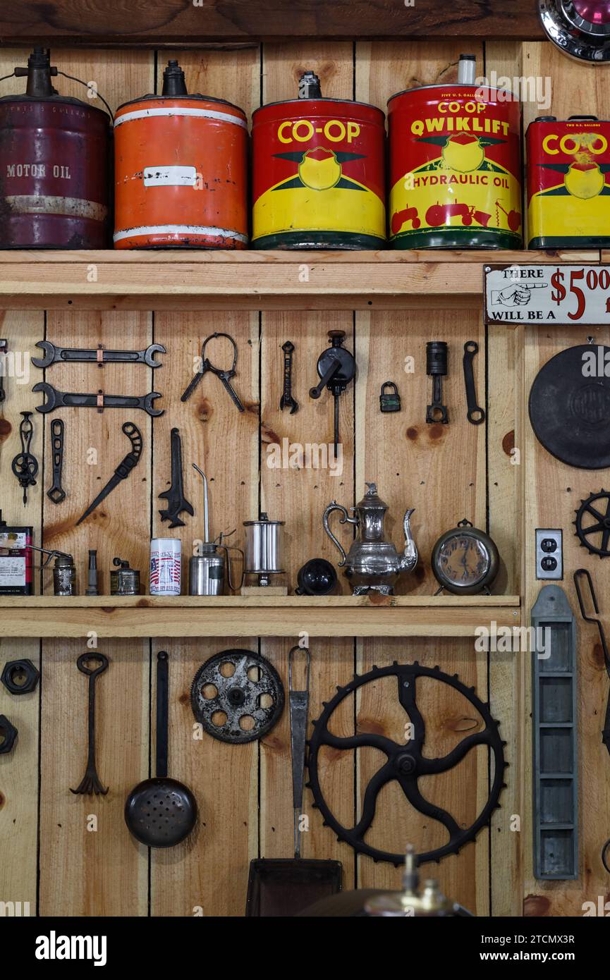 Ölkannen und Werkzeug-Display auf Holzwand - Vintage Stockfoto