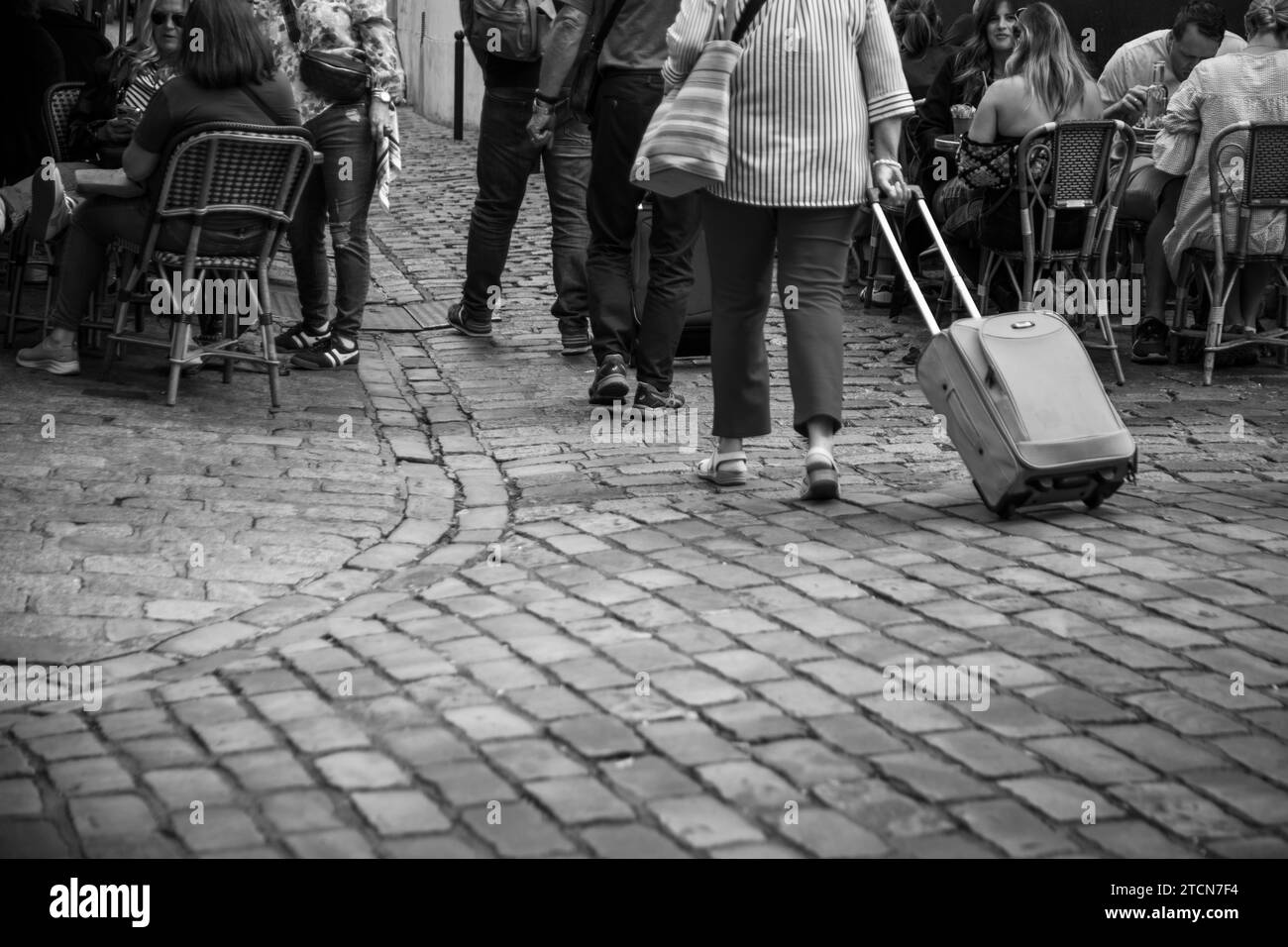 Menschen gehen durch die Kopfsteinpflasterstraßen von Monmartre, Paris, Frankreich Stockfoto