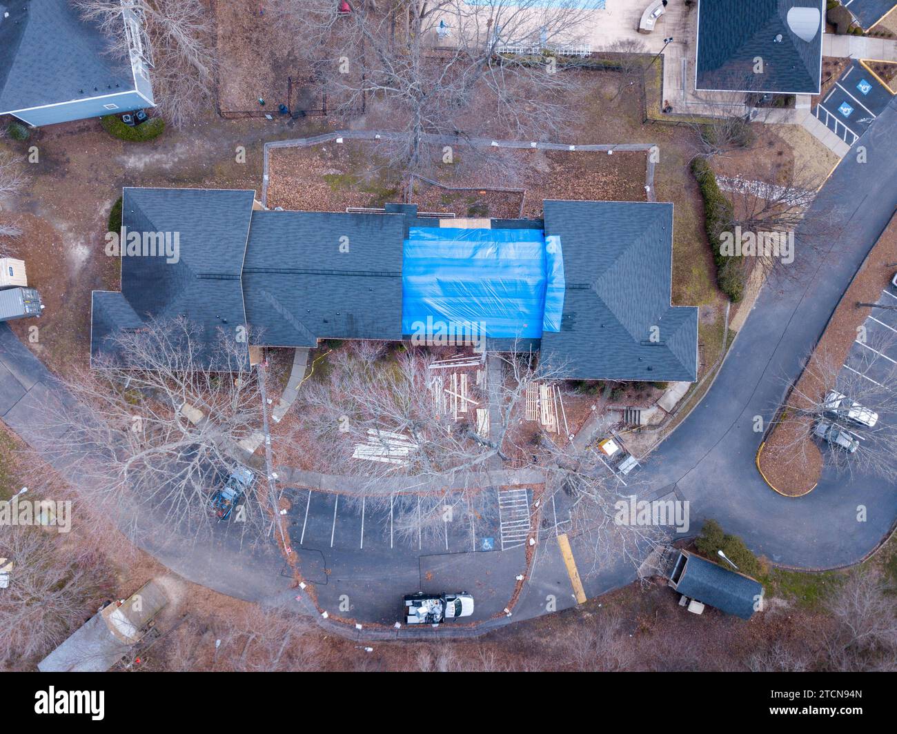 Drohnenbilder eines brennbeschädigten Wohngebäudes mit einer großen Plane, die den betroffenen Bereich bedeckt. Stockfoto