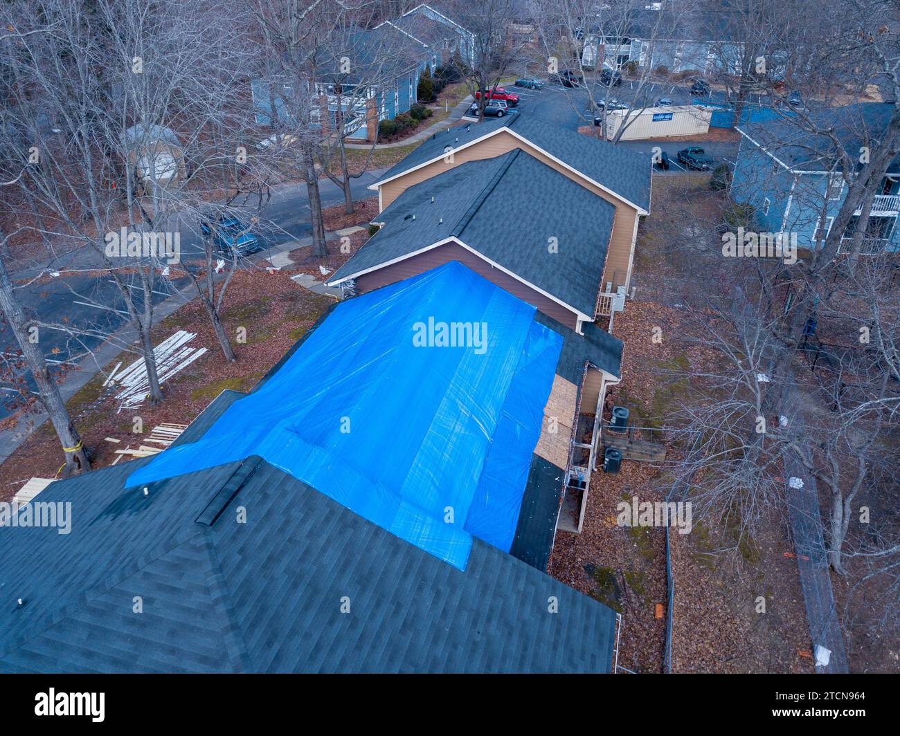Drohnenbilder eines brennbeschädigten Wohngebäudes mit einer großen Plane, die den betroffenen Bereich bedeckt. Stockfoto