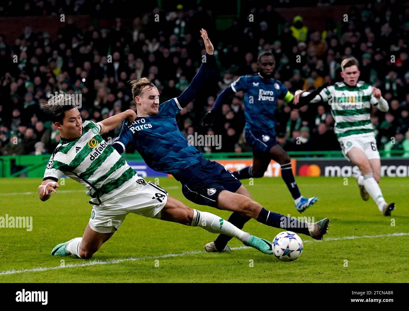 Feyenoords Thomas Beelen und Celtic's Oh Hyeon-Gyu kämpfen um den Ball während des Spiels der UEFA Champions League, Gruppe E im Celtic Park, Glasgow. Bilddatum: Mittwoch, 13. Dezember 2023. Stockfoto