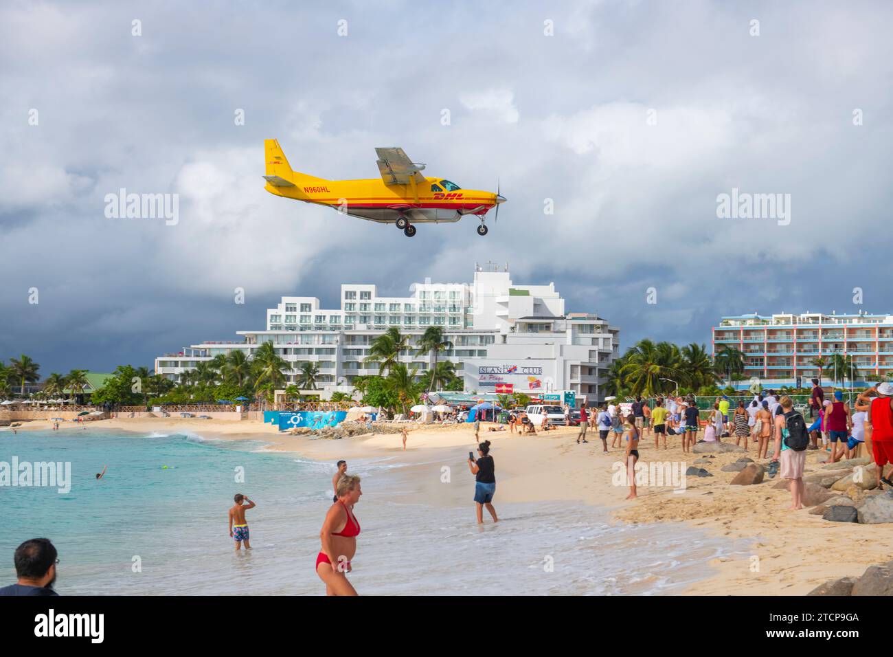 DHL Cessna 208B Super Cargomaster fliegt über Maho Beach, bevor er bei Sonnenuntergang auf dem Princess Juliana International Airport SXM auf Sint Maarten, Niederländisch, landet Stockfoto