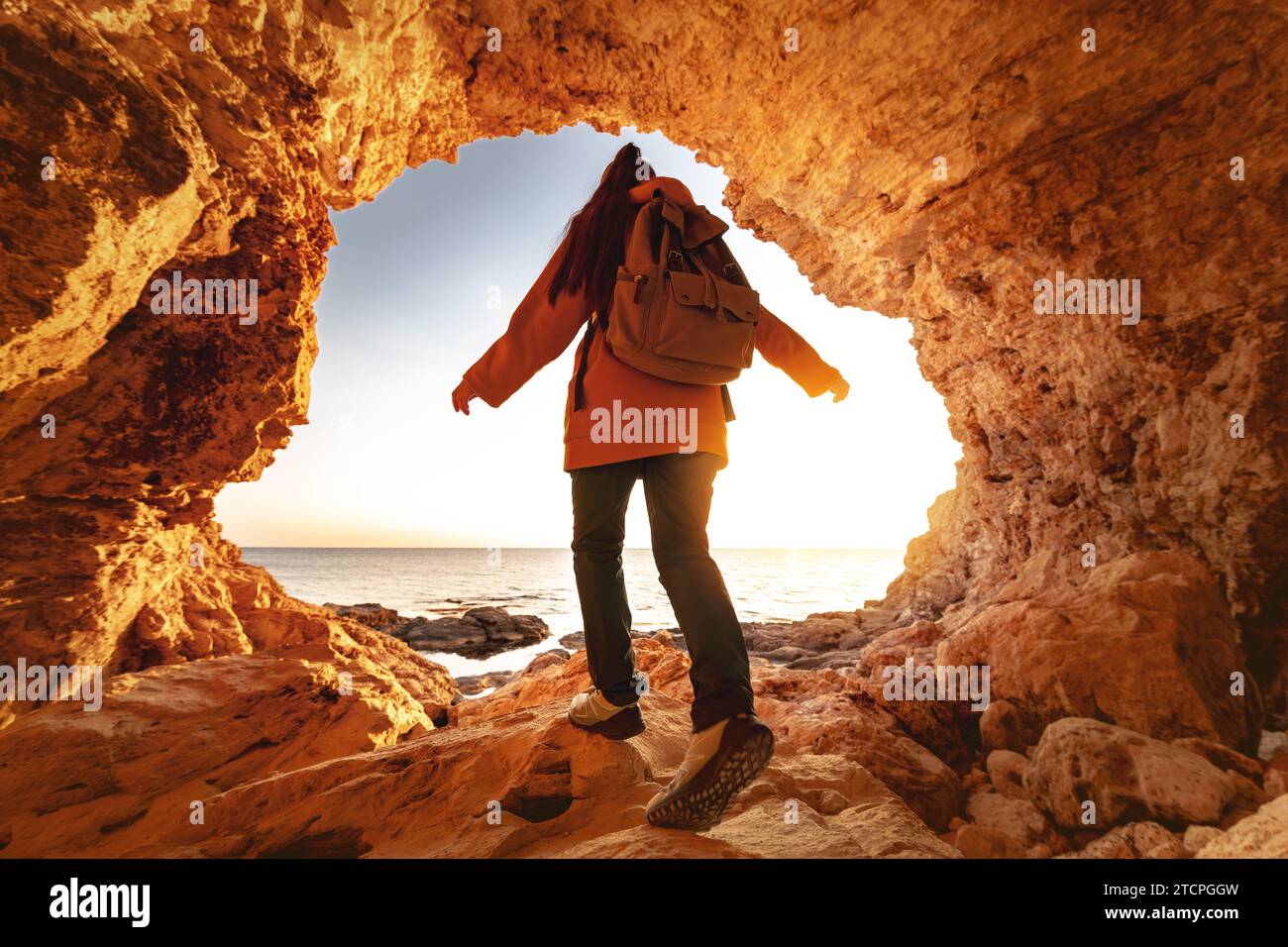 Eine junge Wanderer mit Rucksack erkundet das kleine Großsegel und geht von der Höhle zum Strand Stockfoto