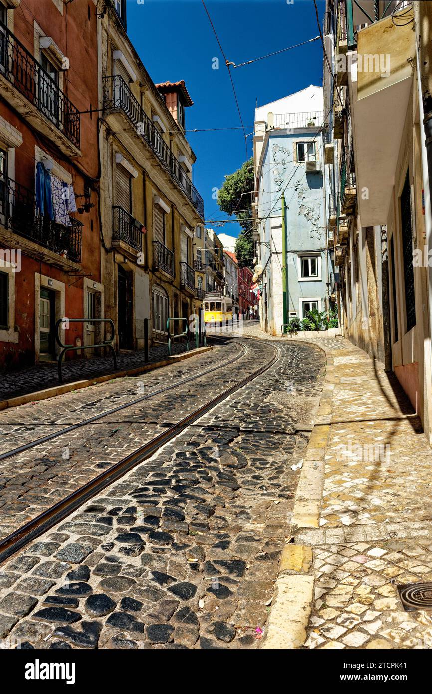 Straße mit gelber Straßenbahn Nr. 28 im Alfama District, Lissabon, Portugal Stockfoto