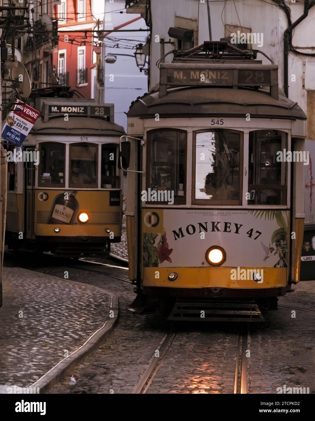 Oldtimer-Straßenbahnen der Linie 28 fahren in der Narrow Street im Alfama-Viertel von Lissabon in der Abenddämmerung, Portugal Europa Stockfoto