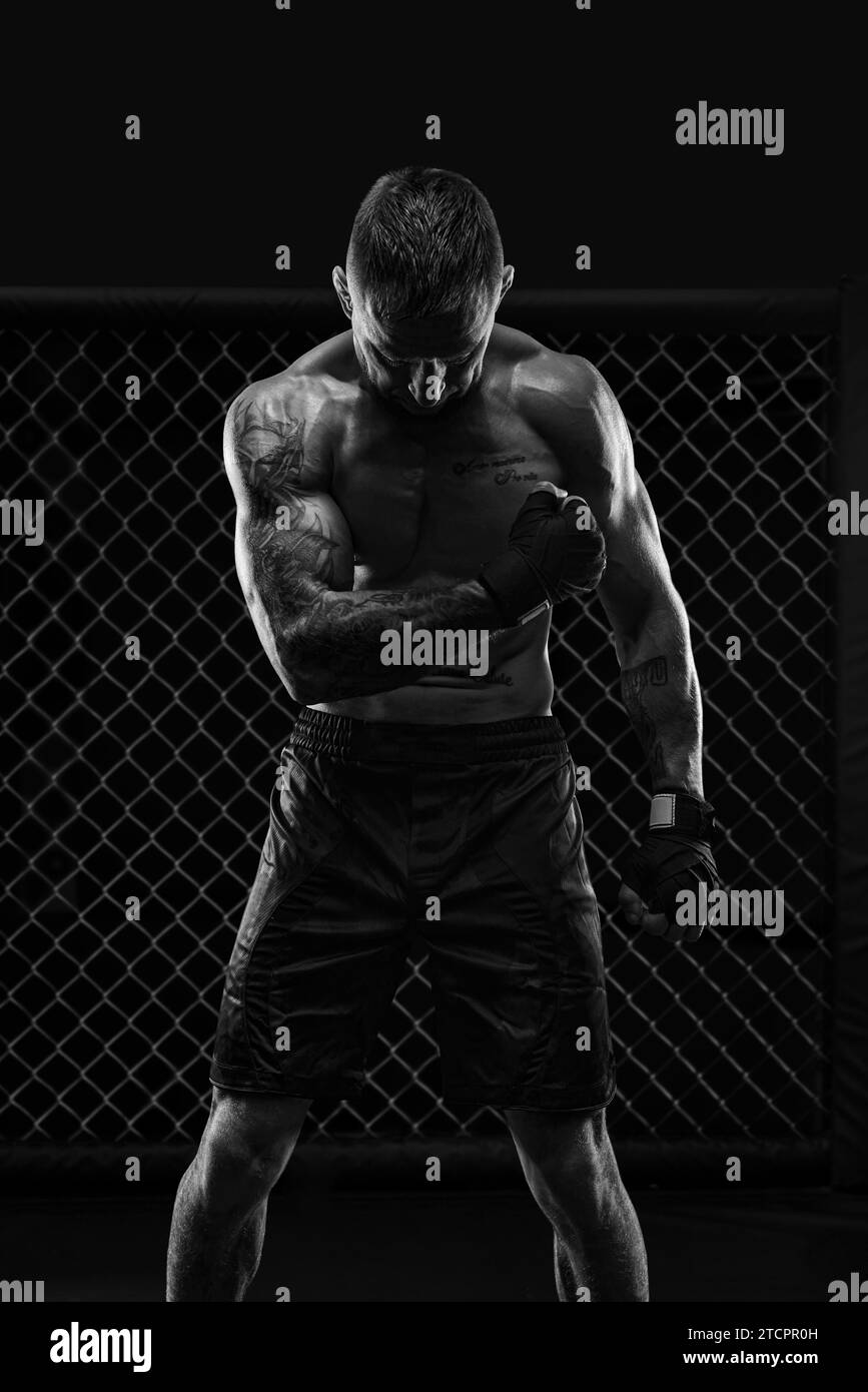 Das dramatische Schwarzweißbild des MMA-Kämpfers. Fotografie in einem echten Achteck. Brutaler Kämpfer. Gemischte Medien Stockfoto