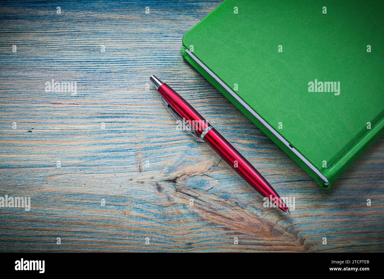 Geschlossener Notizblock-Stift auf Vintage-Holzbrett-Bürokonzept Stockfoto