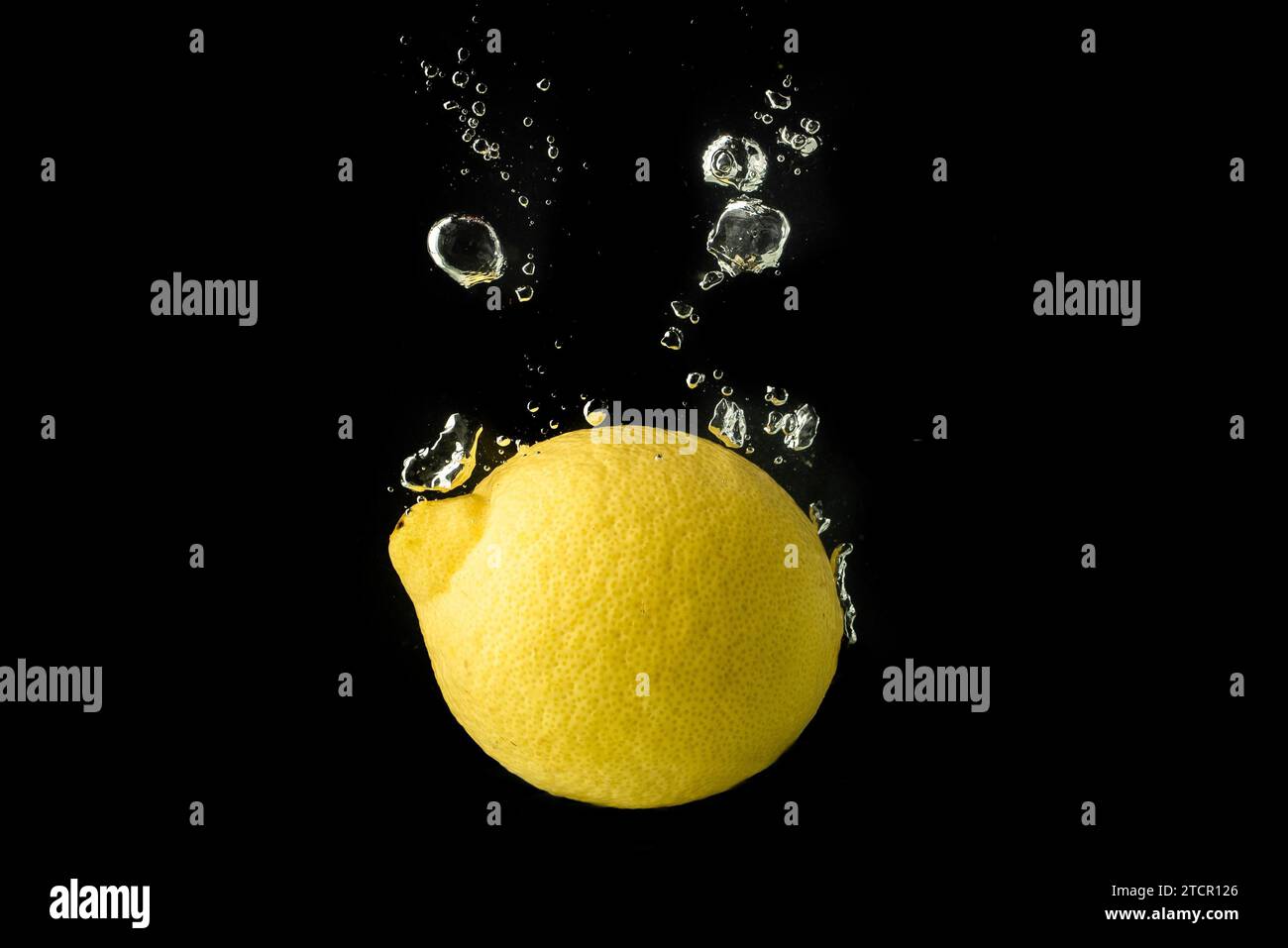 Frucht Spritzer Zitrone in Wasser und sinken auf schwarzem Hintergrund Stockfoto