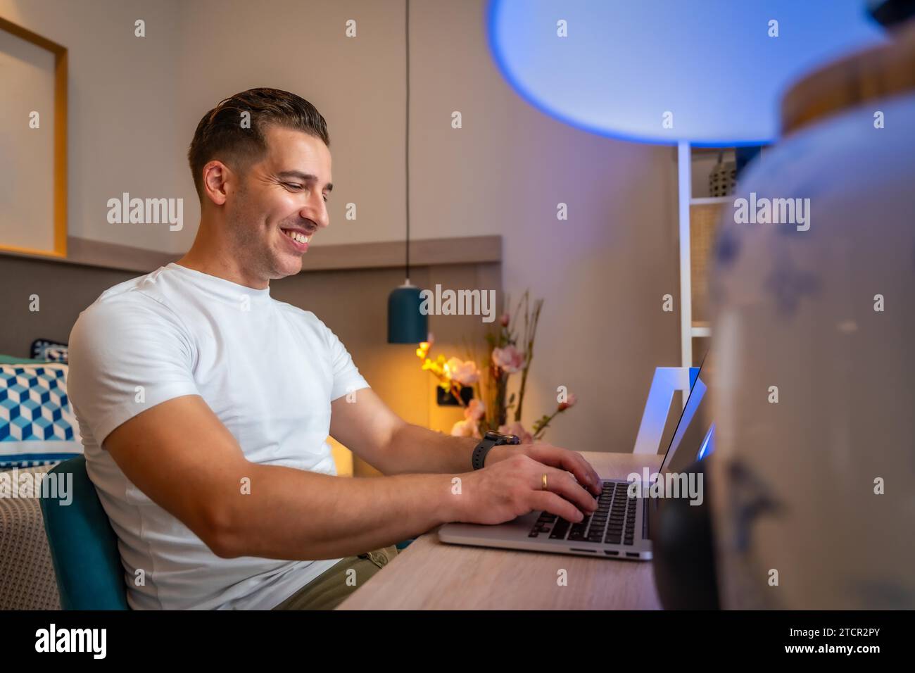 Seitenansicht eines gutaussehenden Mannes, der von zu Hause aus mit einem Laptop arbeitet Stockfoto