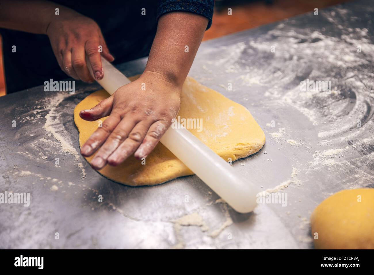 Frau Hand, die Keksenteig mit Nudelnadel ausdrückt Stockfoto