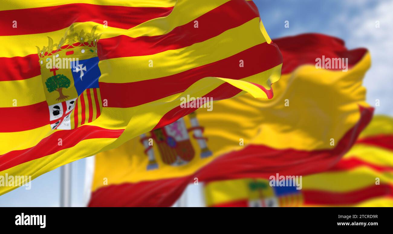 Aragon-Flagge und spanische Flagge winken im Wind. Aragon ist eine autonome Gemeinde im Nordosten Spaniens. Selektiver Fokus. 3D-Darstellung. Clo Stockfoto