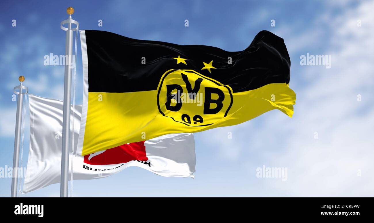 Dortmund, DE, 10. November 2023: Borussia Dortmunder Flagge winkt mit Bundesliga-Flagge an einem klaren Tag. Professioneller deutscher Fußballverein. Illustrative editori Stockfoto