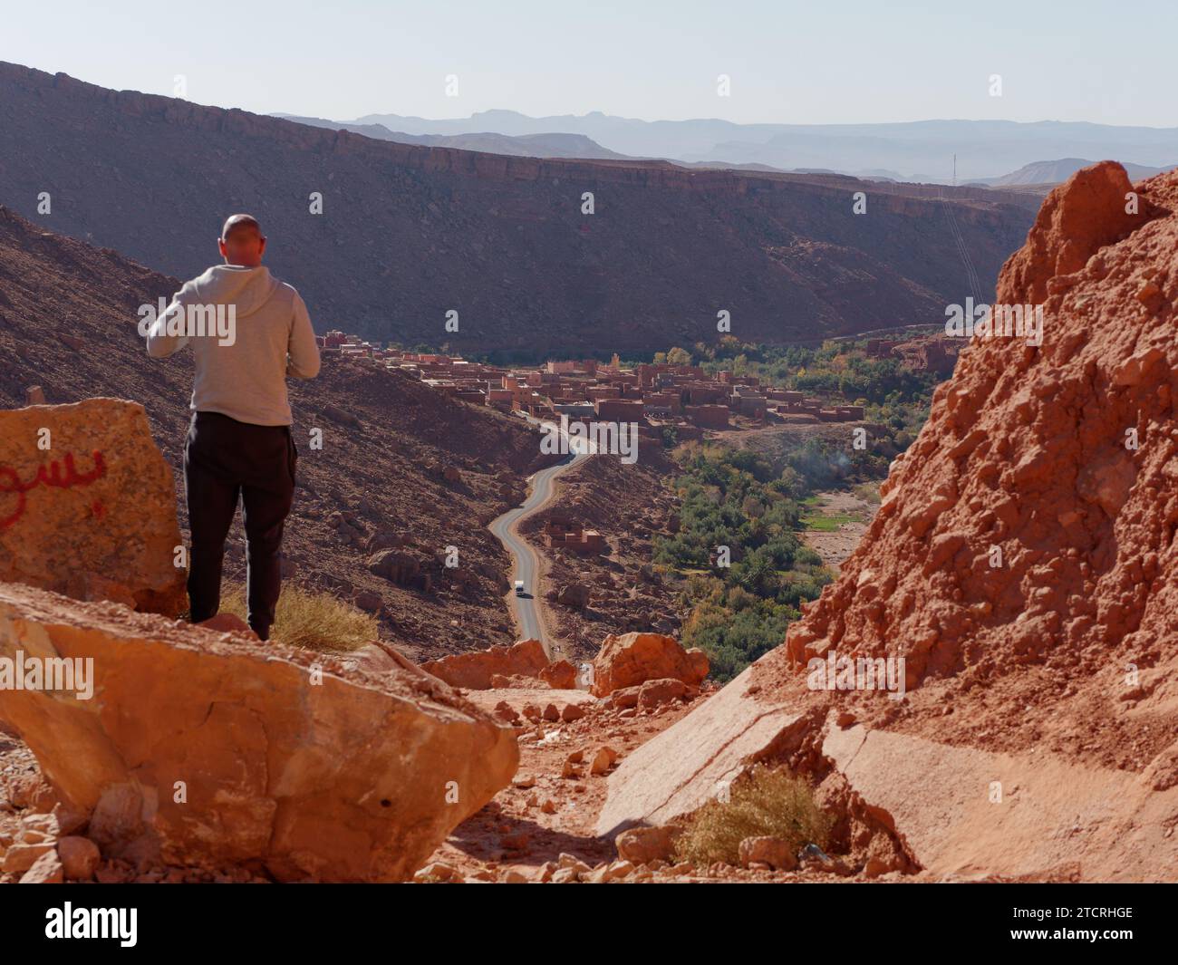 Touristen genießen einen erhöhten Blick über die Straße und das Dorf im Atlasgebirge östlich von Marrakesch, Marokko, 13. Dezember 2023 Stockfoto