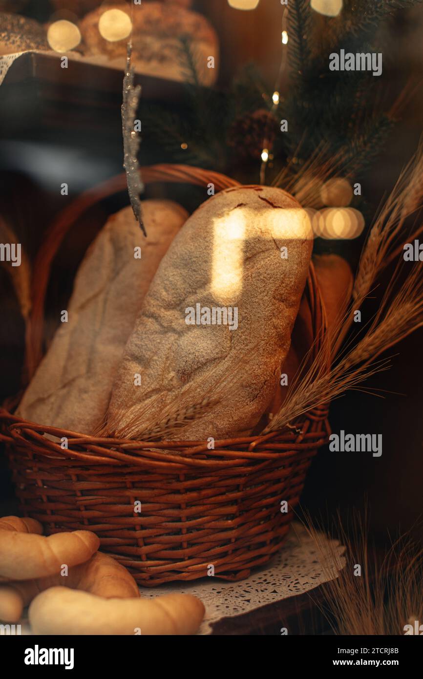 Mehrkornbrot und Weizenohren in einem Korb in einem Frischgebackenladen Stockfoto
