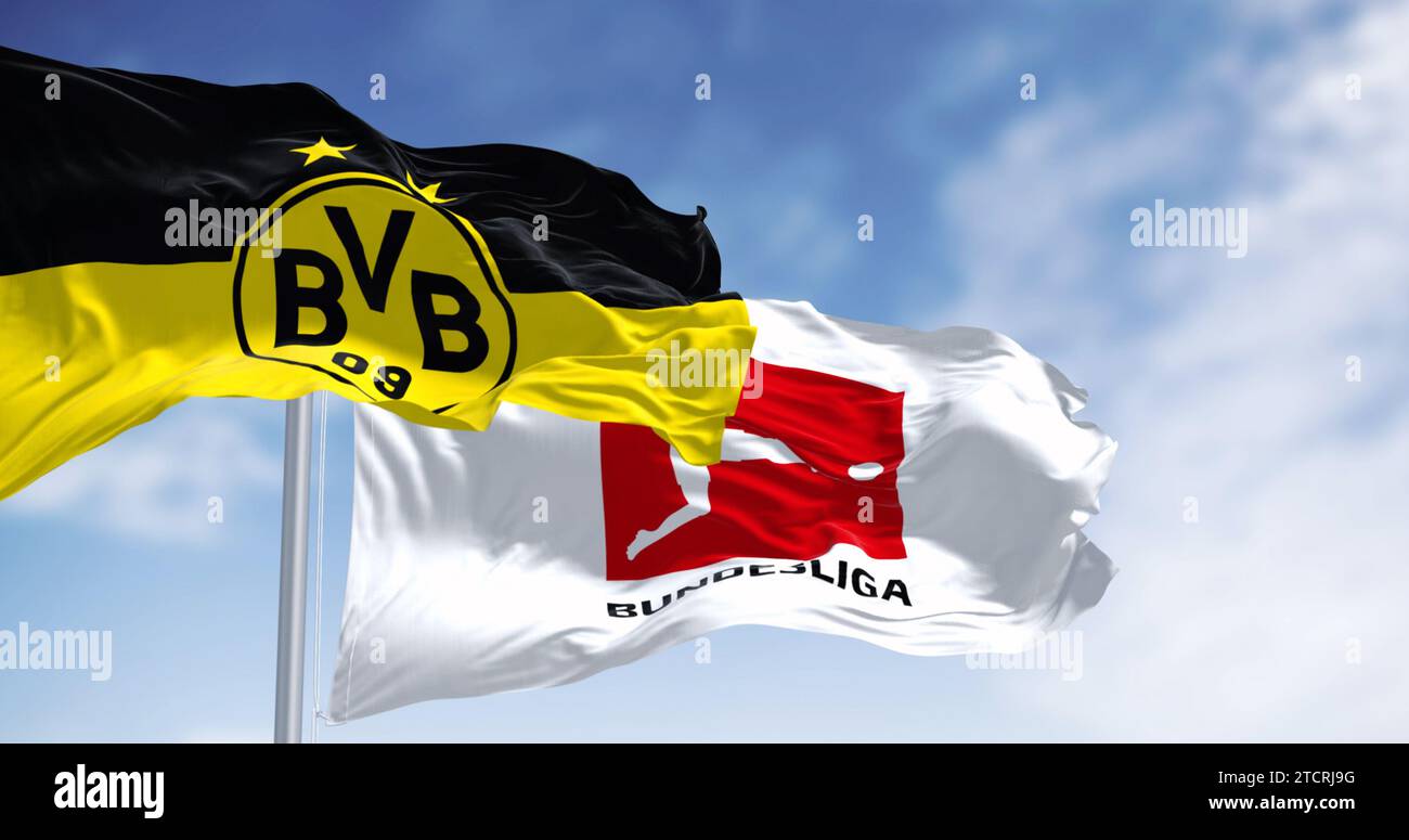 Dortmund, DE, 10. November 2023: Borussia Dortmunder Flagge winkt mit Bundesliga-Flagge an einem klaren Tag. Professioneller deutscher Fußballverein. Illustrative editori Stockfoto