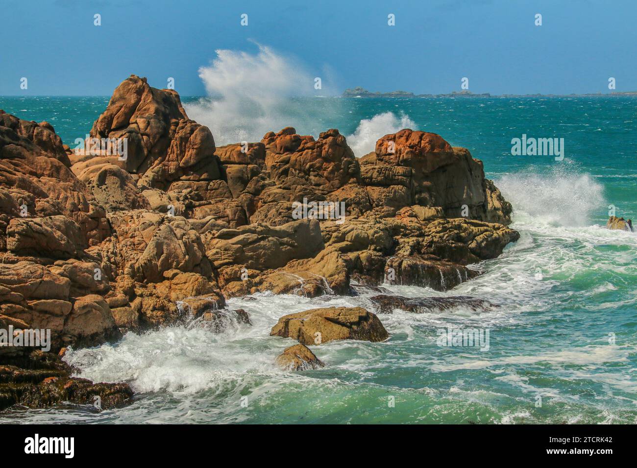 Wellen gegen die erodierten Granitfelsen in Ploumanac'h an der rosafarbenen Granitküste, Côtes-d'Armor, Bretagne, Frankreich Stockfoto