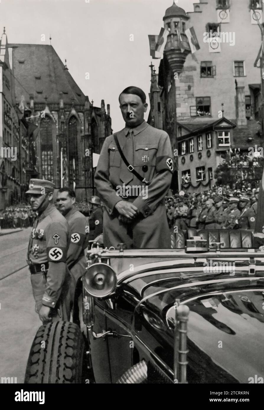 Bei der „Rally of Freedom“ wird Adolf Hitler in seinem Auto gefangen genommen und wartet auf die Ankunft der braunen Säulen, der uniformierten Reihen der SA (Sturmabteilung) und anderer NSDAP-Formationen. Dieses Bild, in dem Hitler über die Massen erhoben wurde, unterstreicht seine dominante Stellung innerhalb der Partei. Die disziplinierten Reihen von SA-Mitgliedern, bekannt für ihre braunen Uniformen, symbolisieren den Fokus der Partei auf militaristische Ordnung und Einheit. Dieser Moment verdeutlicht den orchestrierten Charakter der Nazi-Kundgebungen, bei denen Massenversammlungen und Loyalitätsbekundungen für die Stärkung der Ideologie des Regimes von zentraler Bedeutung waren. Stockfoto