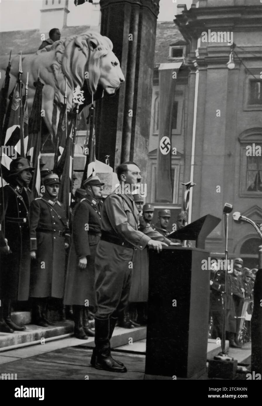 Im November 1934 wird Adolf Hitler in München gefangen genommen und spricht vor der Feldherrnhalle vor den neuen Mitgliedern der Hitlerjugend und des Deutschen Mädchenbundes. Dieses Ereignis war ein bedeutender Moment, als Hitler sich an die jüngere Generation wandte, die in diese Nazi-Organisationen aufgenommen wurde. Die Feldherrnhalle, ein symbolischer Ort in München, bildete eine historisch resonante Kulisse für diesen Anlass. Stockfoto