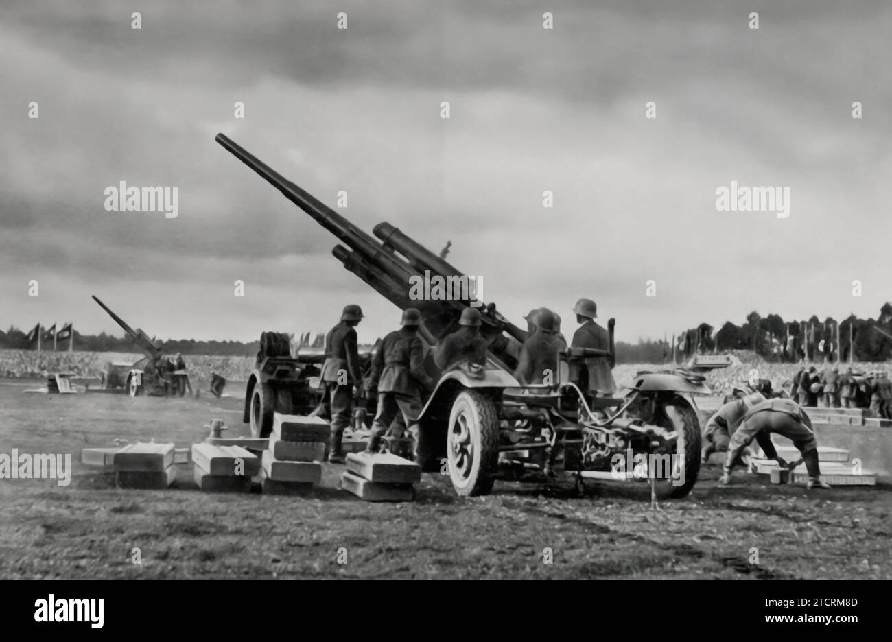 Während des Tags der Wehrmacht 1935 in Nürnberg aufgenommen, zeigt dieses Bild Flugabwehrgeschütze in Position. Sie hebt die militärische Macht und die Bereitschaft hervor, die das Nazi-Regime gezeigt hat, und betont ihre Konzentration auf Luftverteidigungskapazitäten als wichtigen Aspekt ihrer militärischen Demonstrationen und Propaganda. Stockfoto