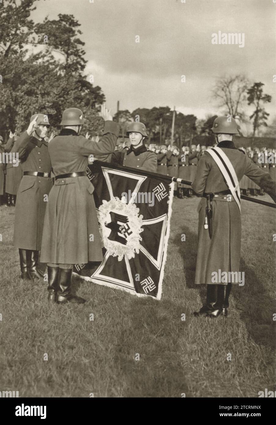 Deutsche Rekruten werden während ihrer militärischen Ausbildung mit dem Führereid auf die deutsche Flagge gefangen genommen. Diese feierliche Zeremonie ist ein bedeutender Moment in ihrer Initiation und symbolisiert ihr Engagement und ihre Loyalität gegenüber dem Regime. Der Akt der Treue zur Flagge, einem mächtigen nationalen Symbol, spiegelt die Indoktrination und das intensive Pflichtgefühl wider, das den Soldaten als Teil ihrer militärischen Indoktrination während dieser Periode der Geschichte eingebracht wurde. Stockfoto