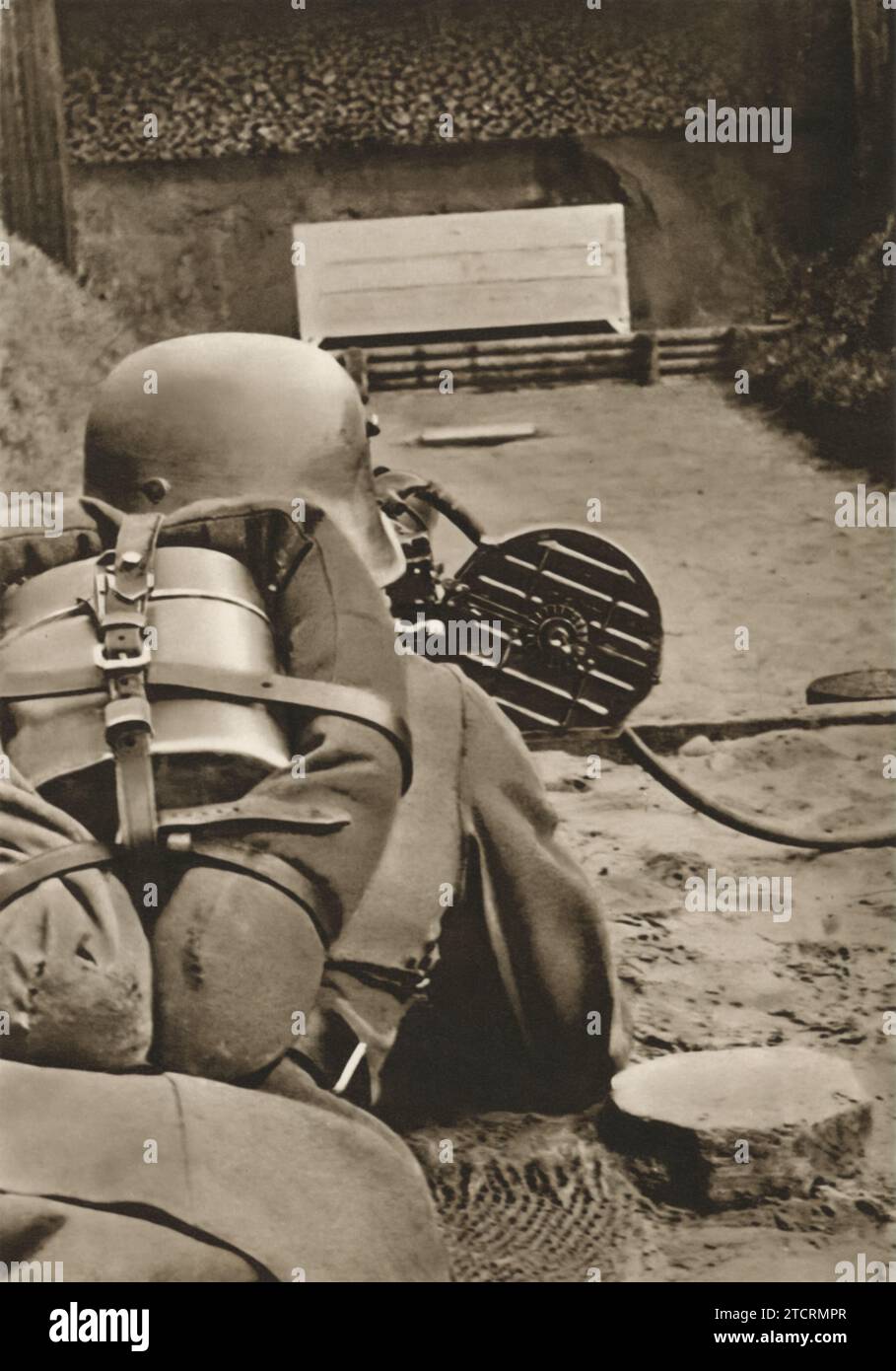 Ein deutscher Rekrut wird in Bauchlage gefangen genommen, der während seiner militärischen Ausbildung zum ersten Mal eine LMG (Light Machine Gun) bedient. Diese Erfahrung ist ein bedeutender Schritt in seinem Training, da er die Grundlagen des Umgangs mit und des Abfeuerns dieser mächtigen Waffe erlernt. Stockfoto