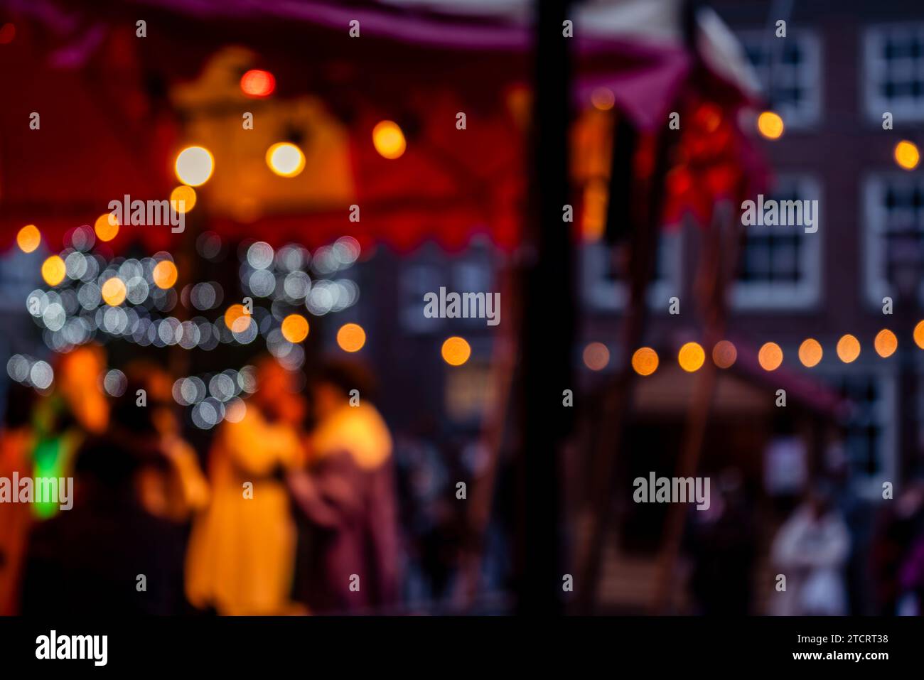 Tauchen Sie ein in die festliche Atmosphäre mit dieser bezaubernden Weihnachtsmarkt-Szene. Bokeh beleuchtet festliche Stände und ein gemütliches Ambiente. Perfekt für Stockfoto