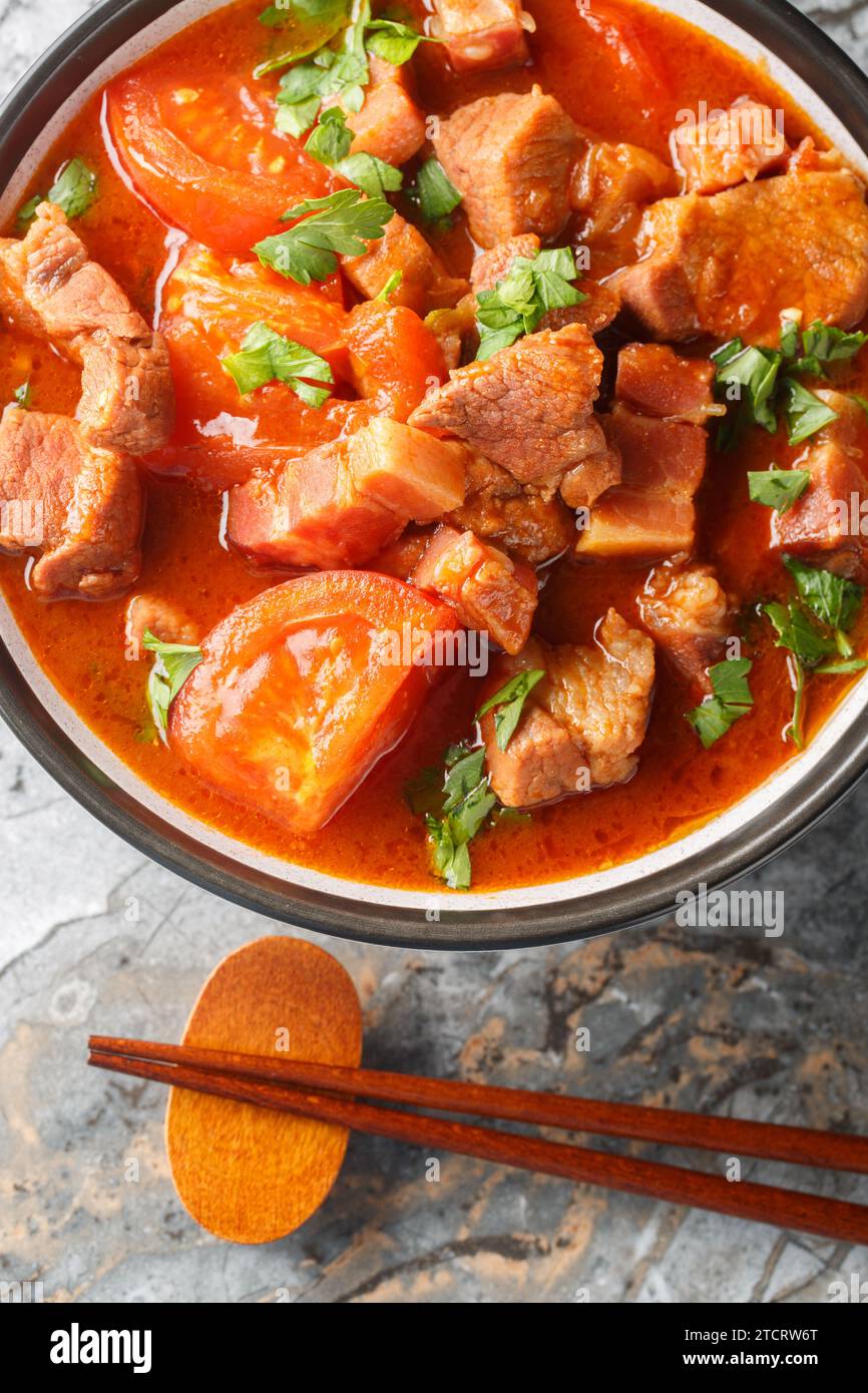 Babi Masak Tomat ist ein traditionelles indonesisches Gericht, das aus einer Kombination aus Schweinefleisch, Tomaten, Zwiebeln, Knoblauch, Zitronengras, und eine Gewürzpaste Nahaufnahme in t Stockfoto