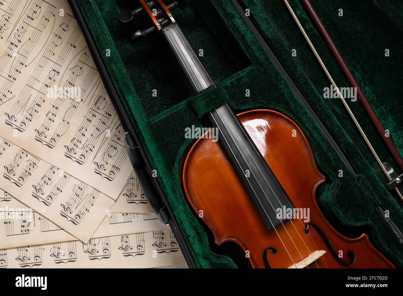 Violine, Bogen im Etui und Notenblätter auf dem Tisch, Draufsicht Stockfoto