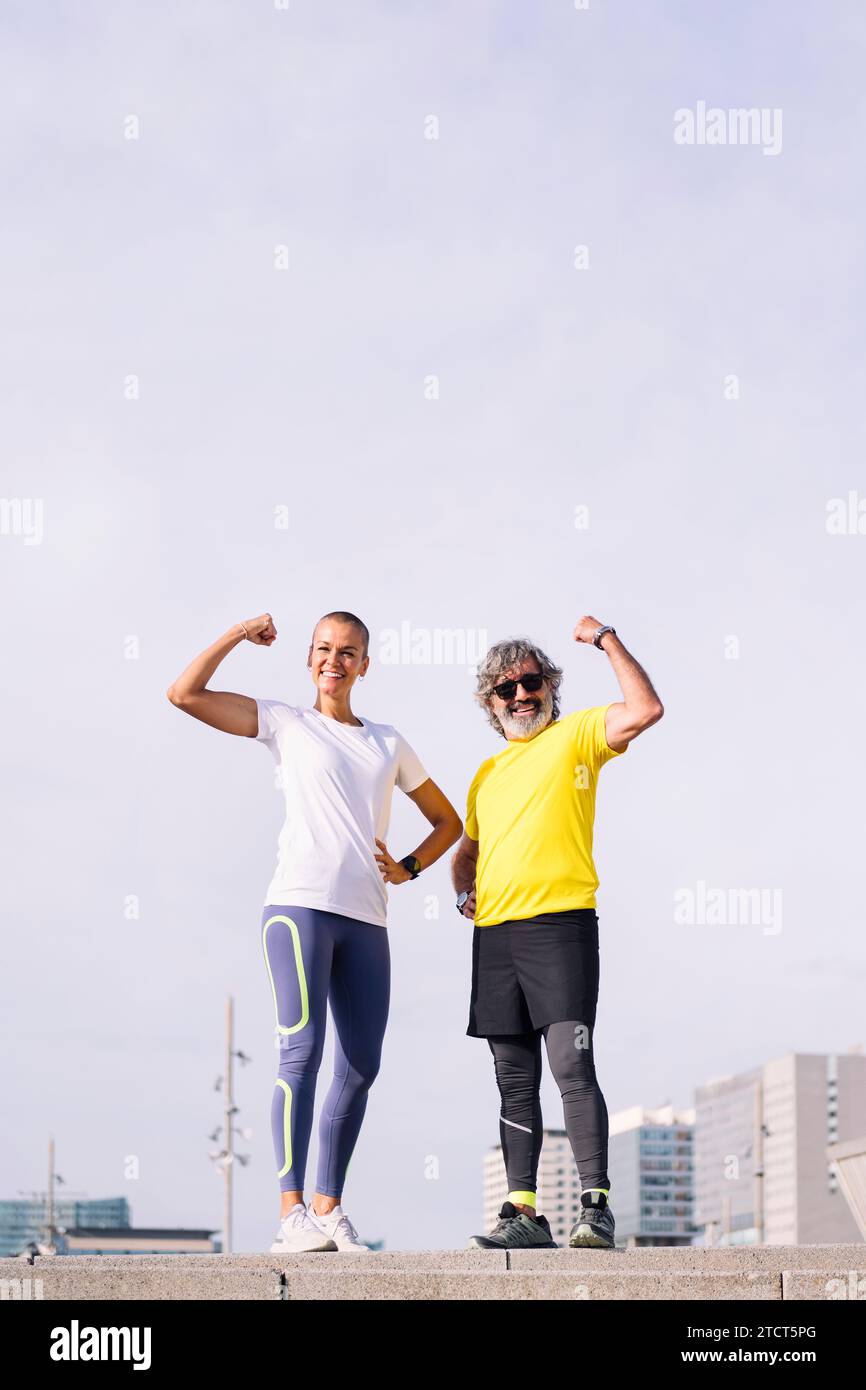 Senior-Mann und sein Trainer posieren beugende Muskeln Stockfoto