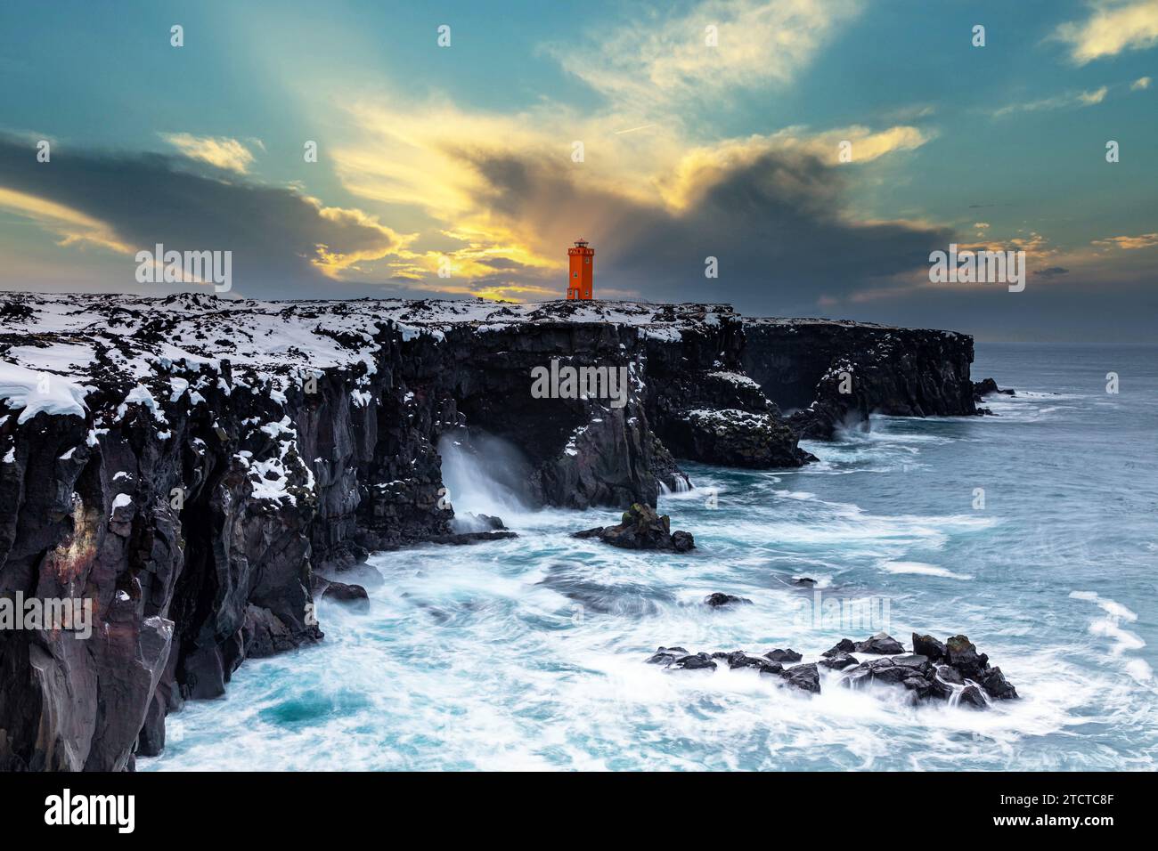 Der orangefarbene Leuchtturm von Svörtuloft auf den schwarzen Klippen Islands im Winter Stockfoto