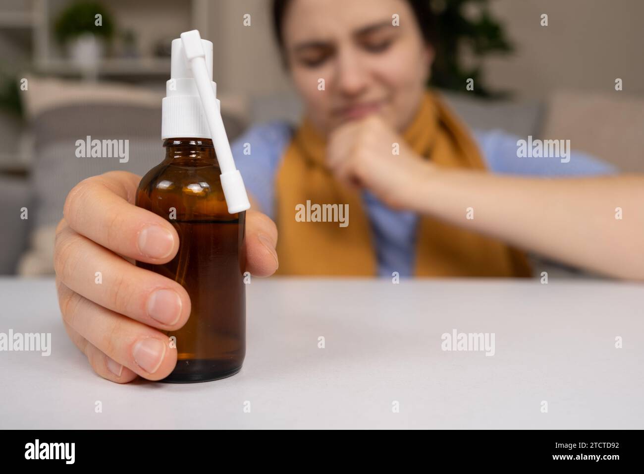 Eine Flasche Arzneimittel zur Behandlung von Halsschmerzen und Husten in der Hand eines Patienten Stockfoto