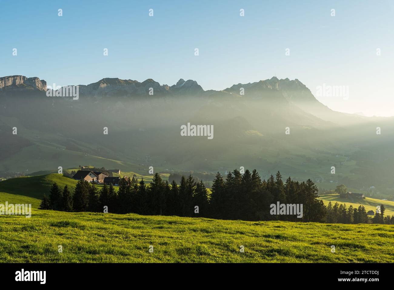 Ländliche Landschaft im Appenzeller Raum mit Bauernhäusern und Wiesen im letzten Licht der Abendsonne, Blick auf die Alpsteinberge mit Saentis Stockfoto