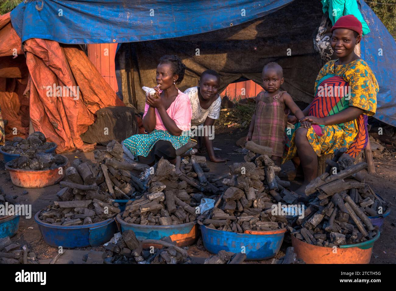 Holzkohleverkäuferin und ihre Tochter auf dem Masindi Market, Western Region, Uganda Stockfoto