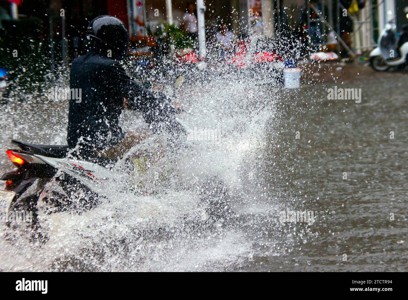 Saison Monsun. Starker Regen und Wasserabfall auf der Straße. Motorrad. Stockfoto