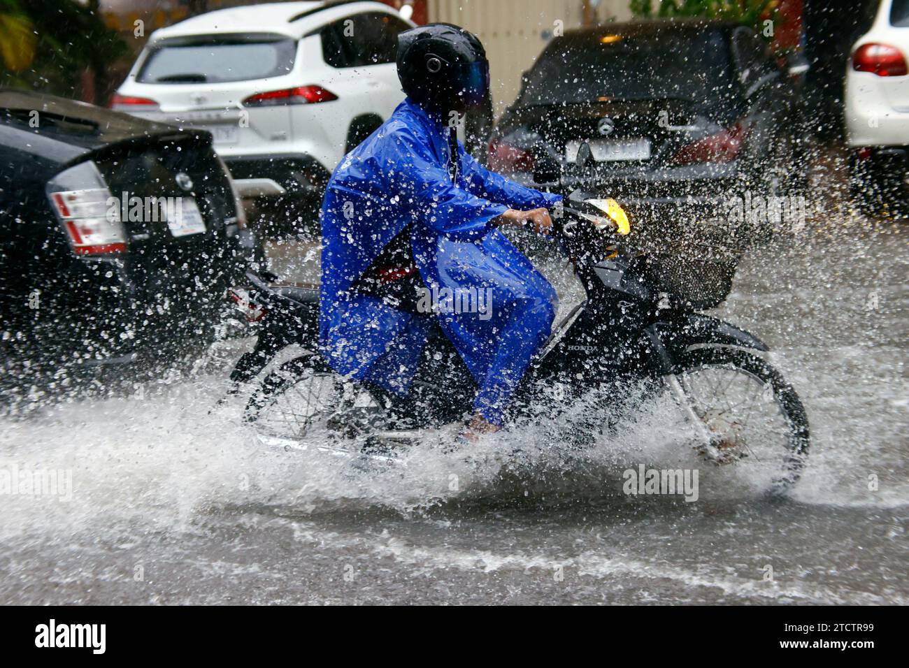 Saison Monsun. Starker Regen und Wasserabfall auf der Straße. Motorrad. Stockfoto