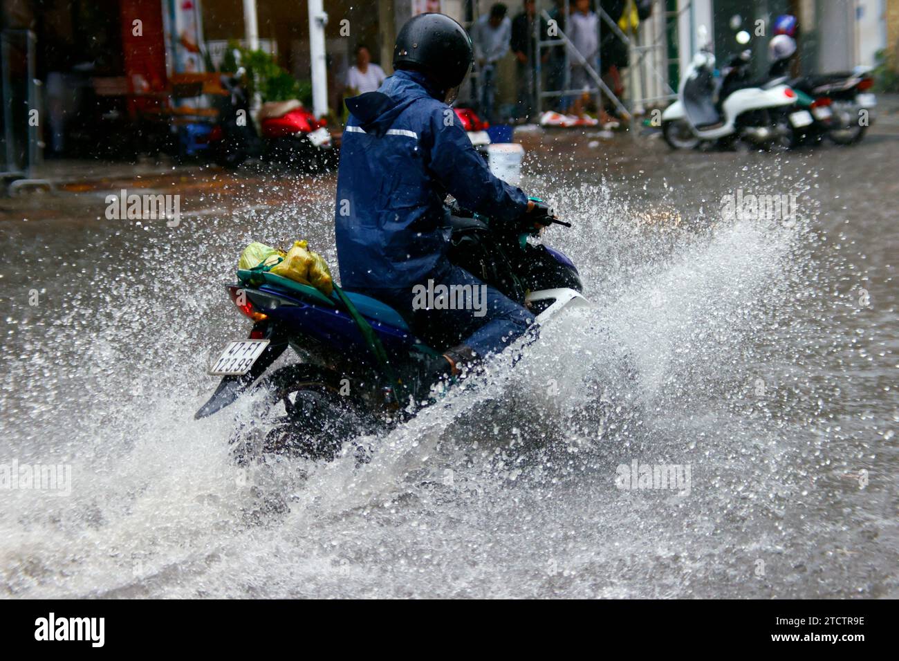 Saison Monsun. Starker Regen und Wasserabfall auf der Straße. Motorrad. Stockfoto