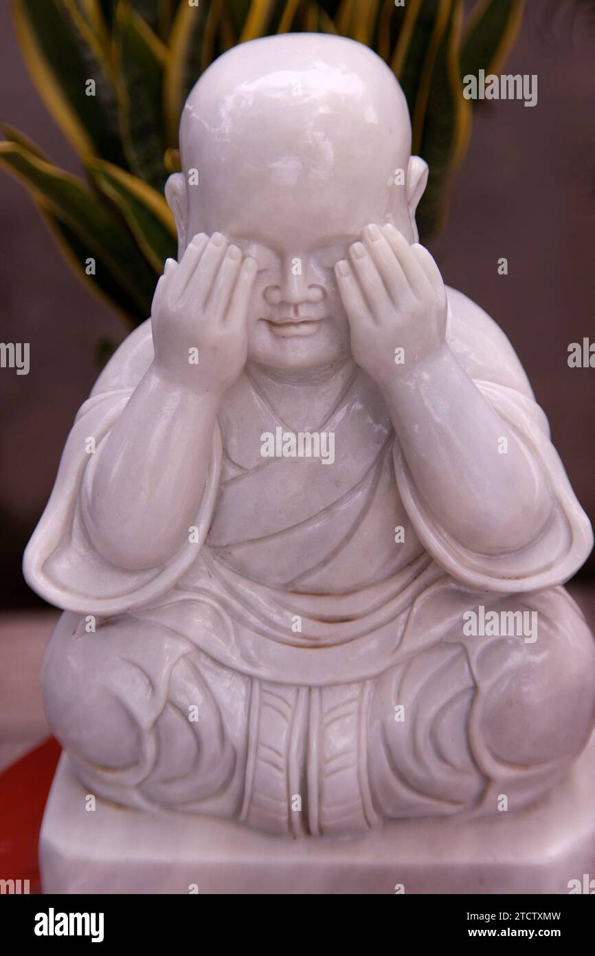 Phuoc Hue buddhistische Pagode. buddhistische Mönchsstatue aus Marmor in einem Garten mit Handbetätigung, um die Augen zu schließen. Drei-Affen-Konzept. Vietnam. Stockfoto