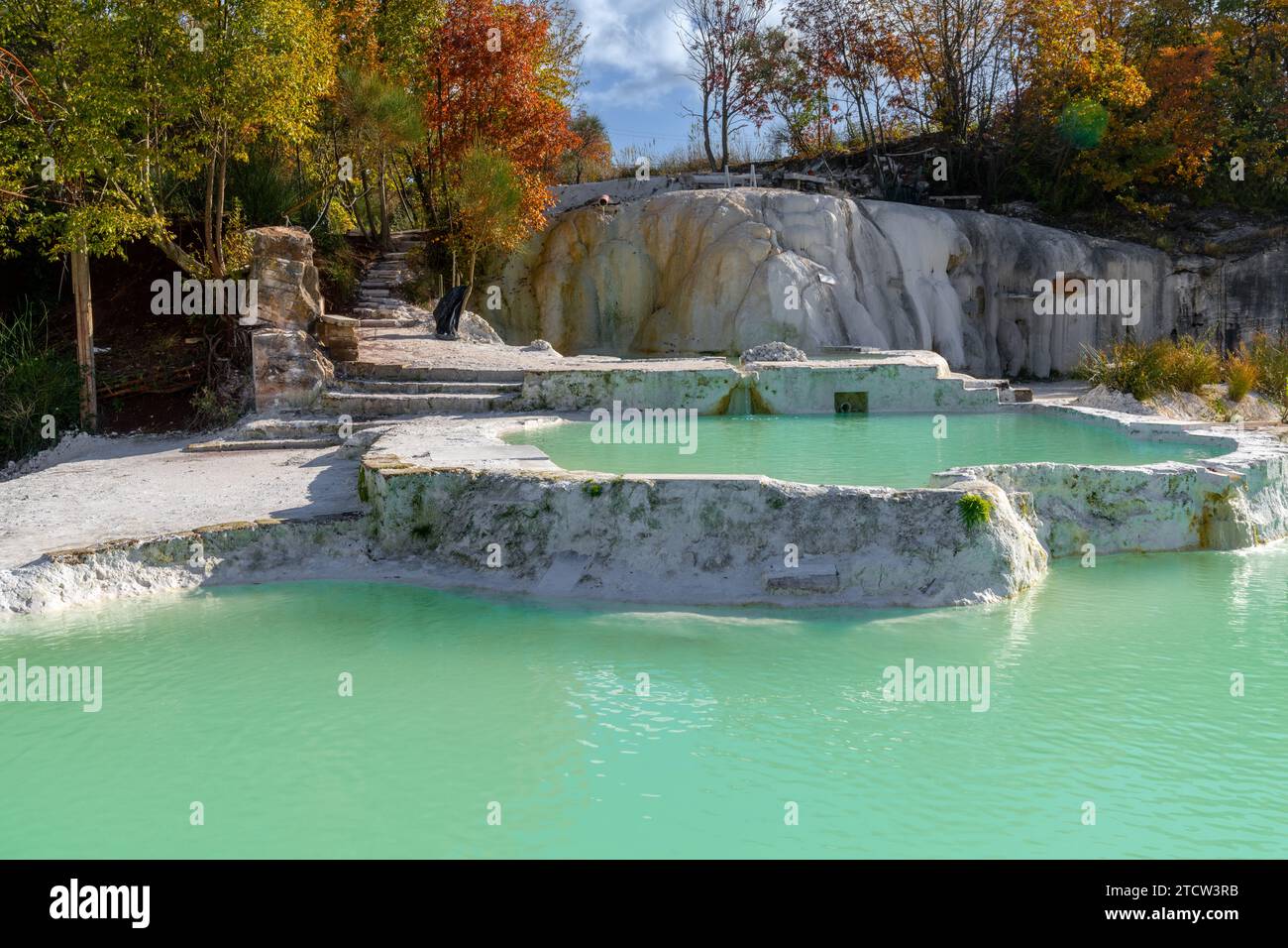 Malerische Thermalbäder mit türkisfarbenem Wasser unter Laubbäumen in Bagni San Filippo Stockfoto