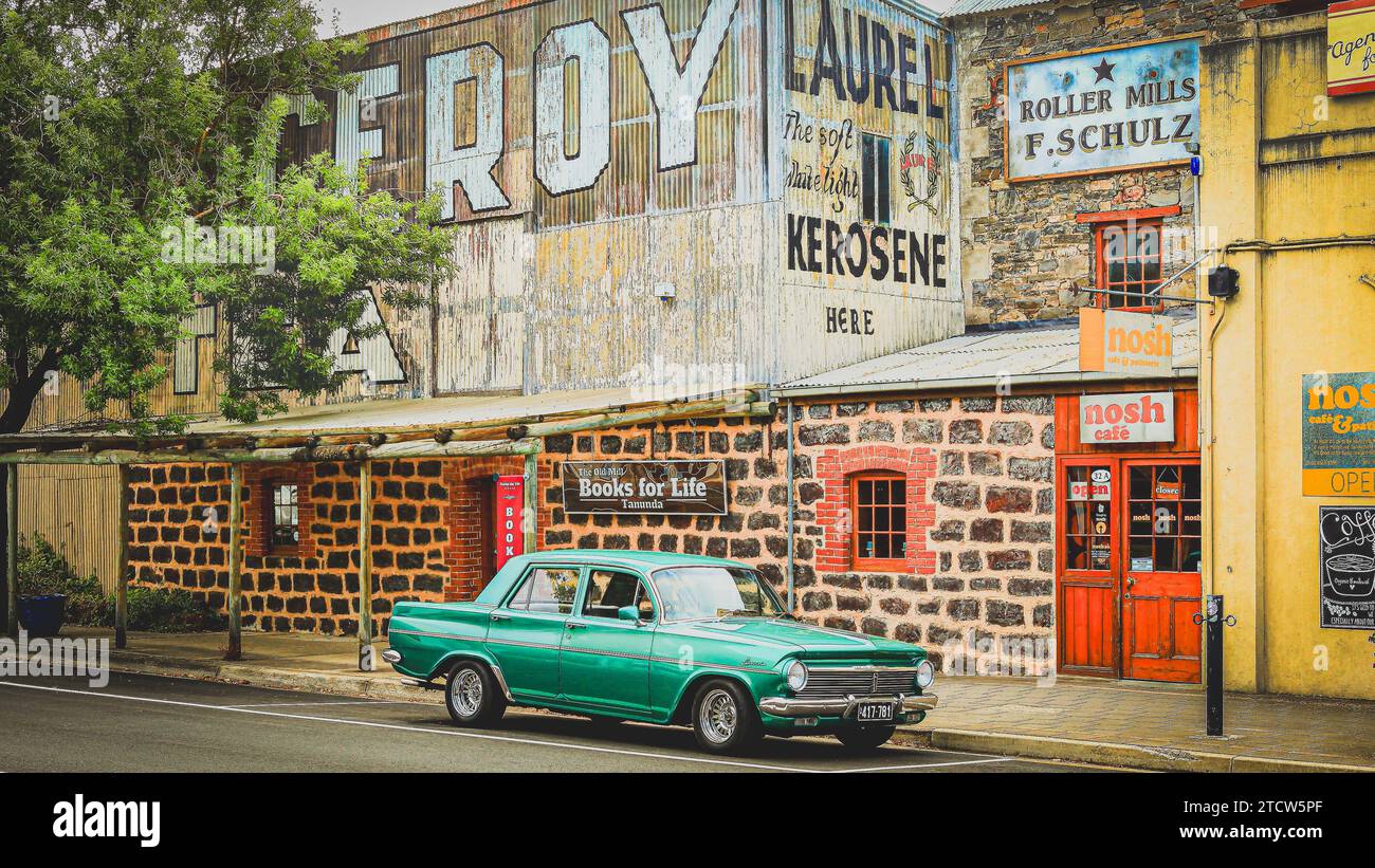 Ein altes grünes Auto vor dem Nosh Cafe mit Garagenhintergrund Stockfoto