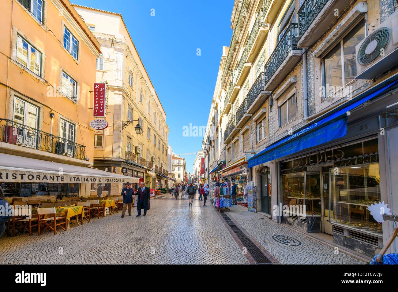 Die beliebte Straße Rua Augusta, in der viele Shopper und Restaurants und Cafés auf dem Bürgersteig in Lissabon, Portugal, genießen. Stockfoto