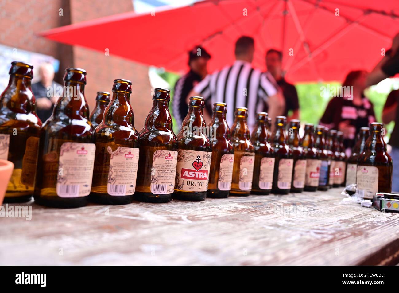 Astra-Bierflaschen hintereinander in einem Kneipengarten in Hamburg Stockfoto