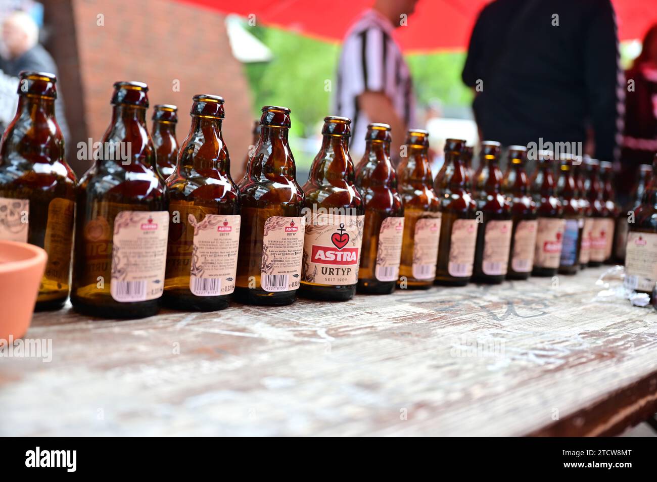Astra-Bierflaschen hintereinander in einem Kneipengarten in Hamburg Stockfoto