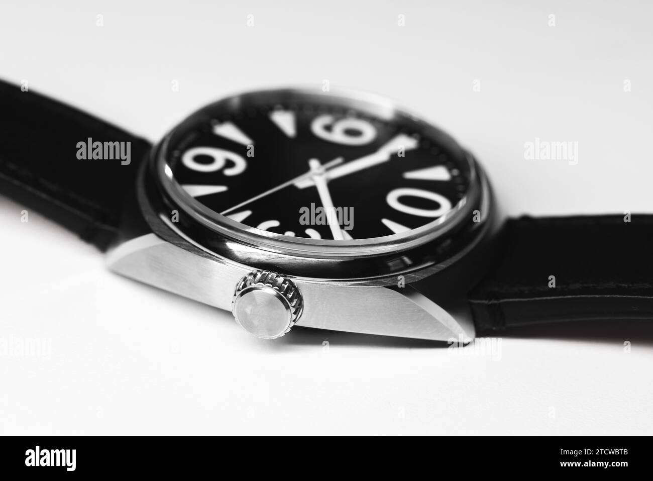 Automatische mechanische Armbanduhr mit kräftigen weißen Ziffern auf schwarzem Zifferblatt im Stahlgehäuse, Nahaufnahme Studiofoto auf weißem Hintergrund Stockfoto