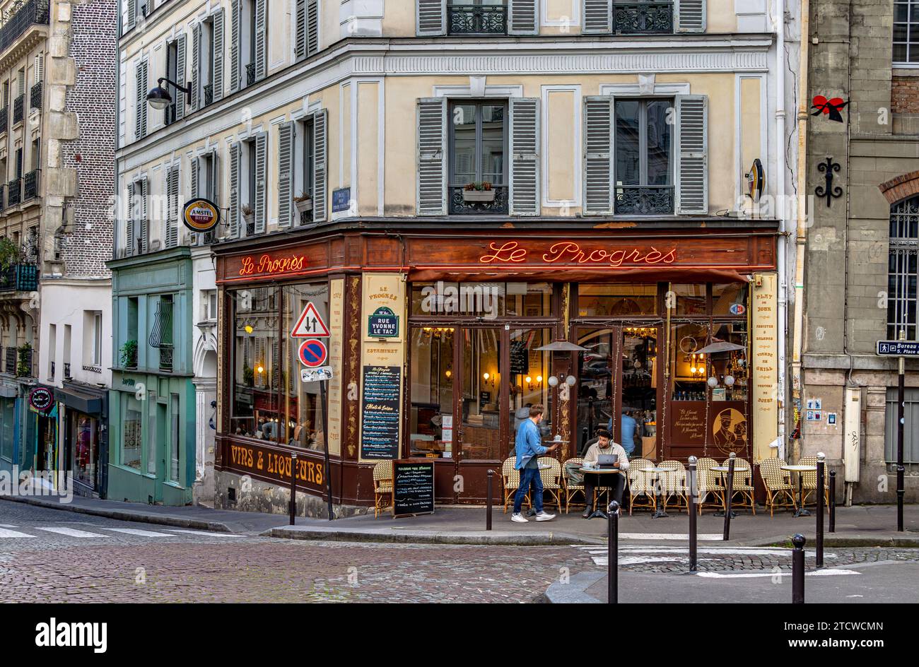 Ein Mann, der vor dem Le Progrès, einem Bistro und Café in Montmartre im ht e18 Arrondissement von Paris, Frankreich, Tee serviert hat Stockfoto