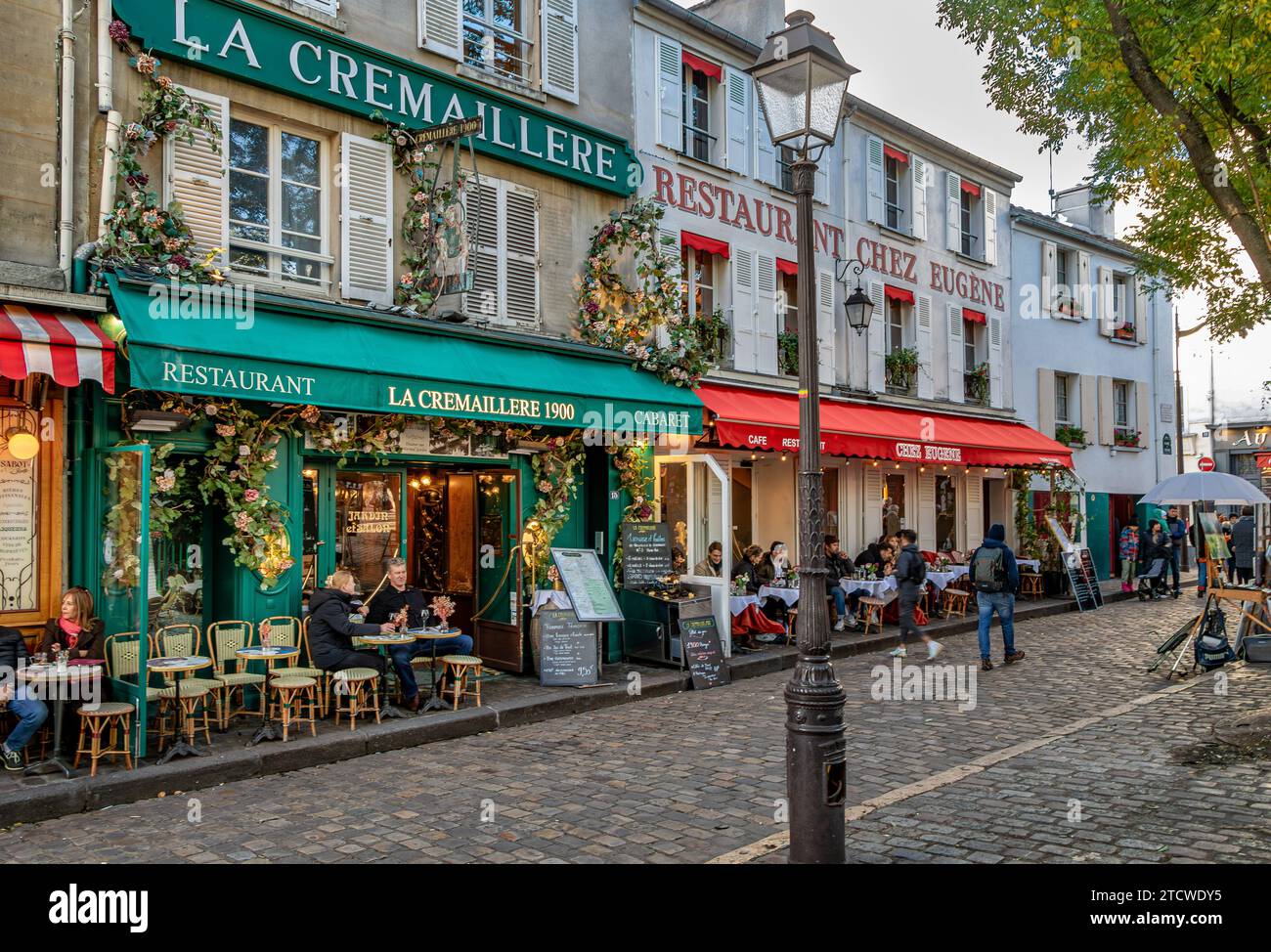 Personen, die am späten Nachmittag an einem Wintertag vor La Crémaillère 1900 sitzen, in Place du Tertre, Montmartre, Paris, Frankreich Stockfoto